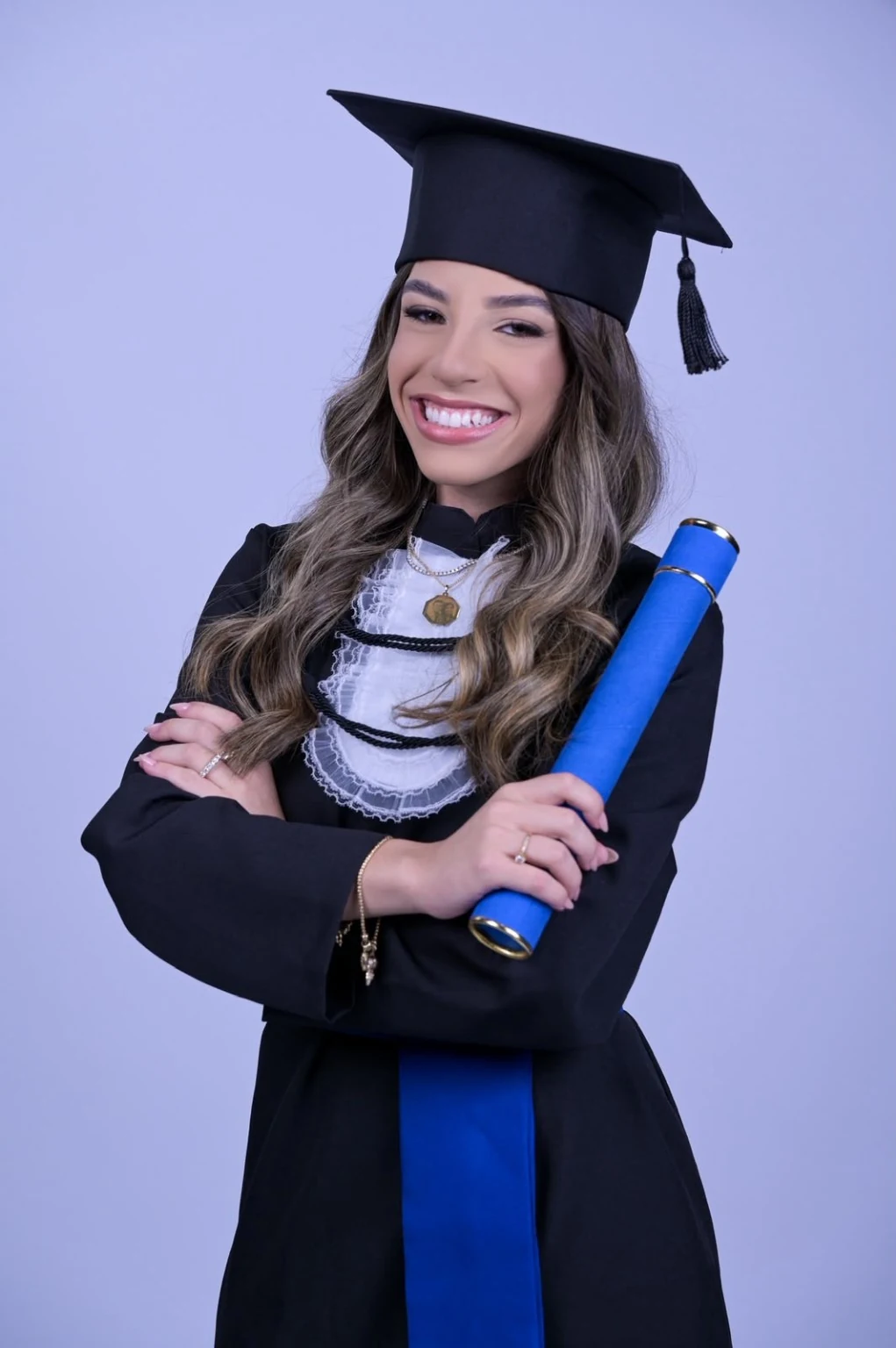 Vitória com beca e capelo, segurando o diploma